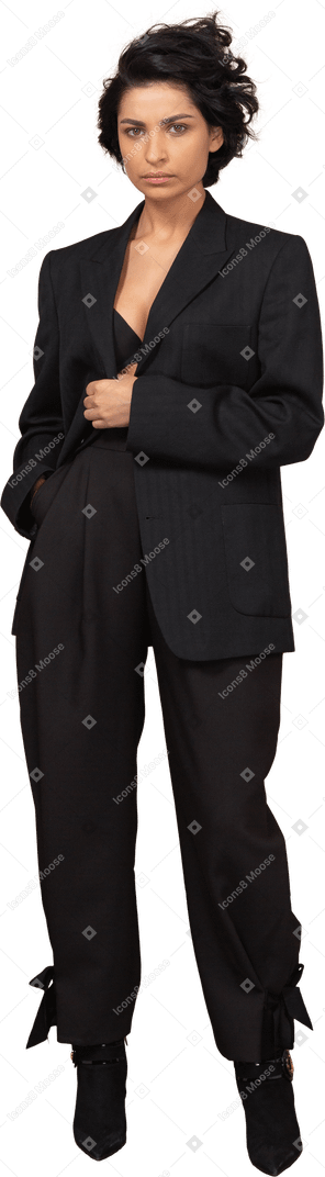 Vista frontal de una mujer de negocios en un traje negro mirando seriamente a la cámara