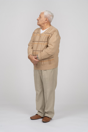 Front view of an old man in casual clothes looking up