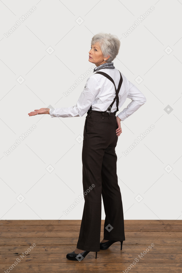 Side view of an old lady in office clothing outstretching her hand
