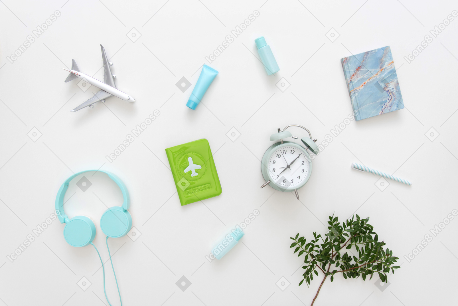 Blue heaphones, passport cover, alarm clock, airplane model and notebook