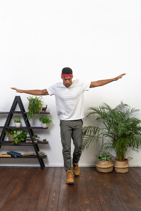 Good looking young man posing on the background of the apartment