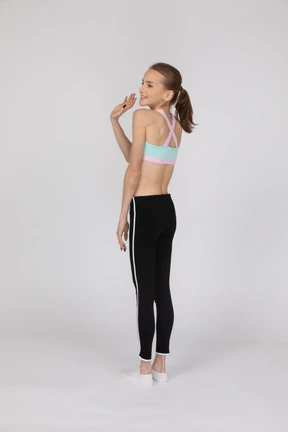 Side view of a teen girl in sportswear raising hand and arguing