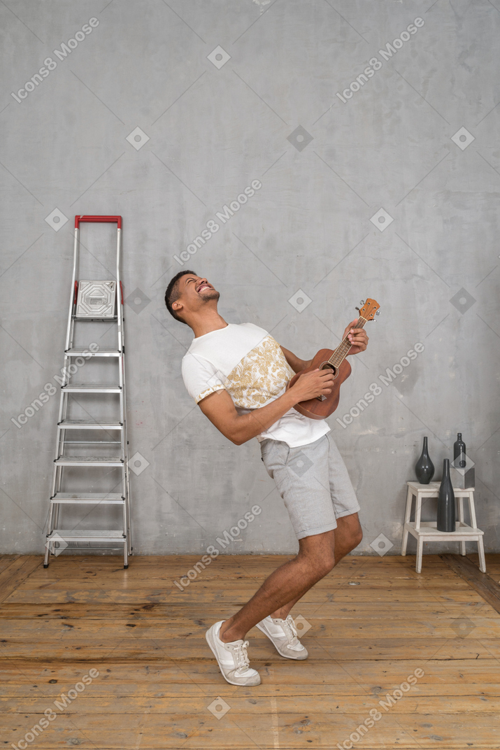 Vista di tre quarti di un uomo che dondola sull'ukulele