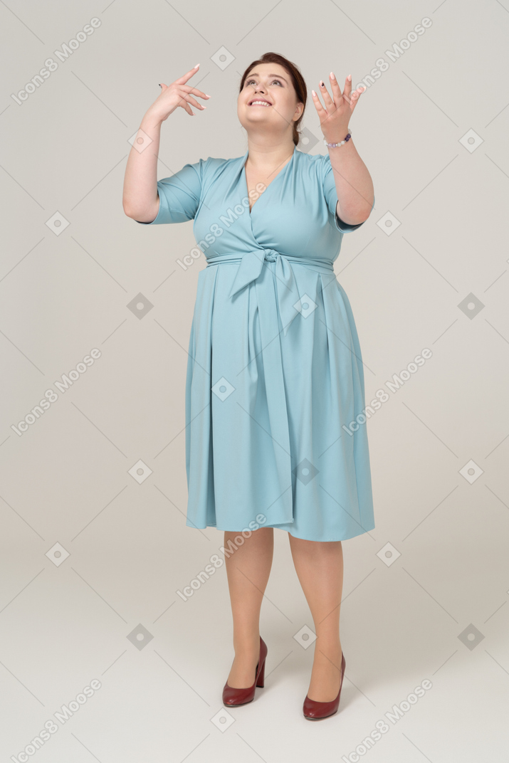Vista frontal de uma mulher de vestido azul olhando para cima
