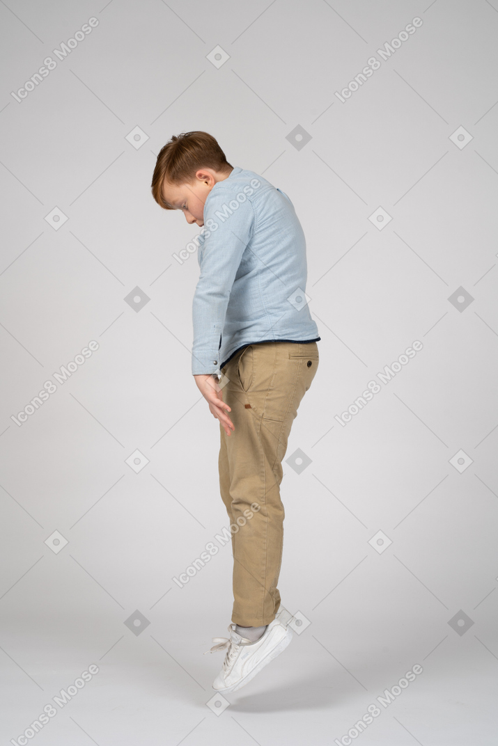 Side view of a boy jumping and looking down