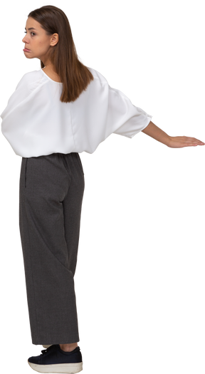 Vista traseira de uma jovem com roupas de escritório estendendo a mão