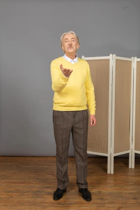 Front view of an old man sending an air kiss