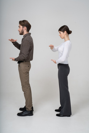 Side view of a young couple in office clothing showing size of something