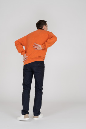 Young man in orange sweatshirt standing