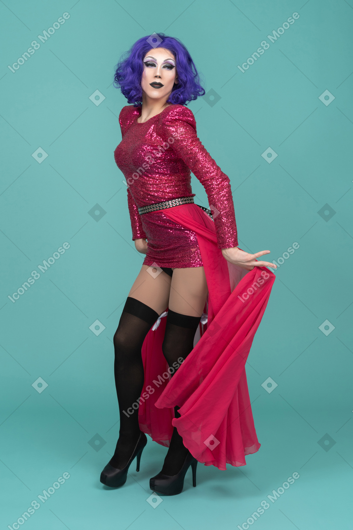 Portrait of a drag queen in pink dress moving long skirt out of the way