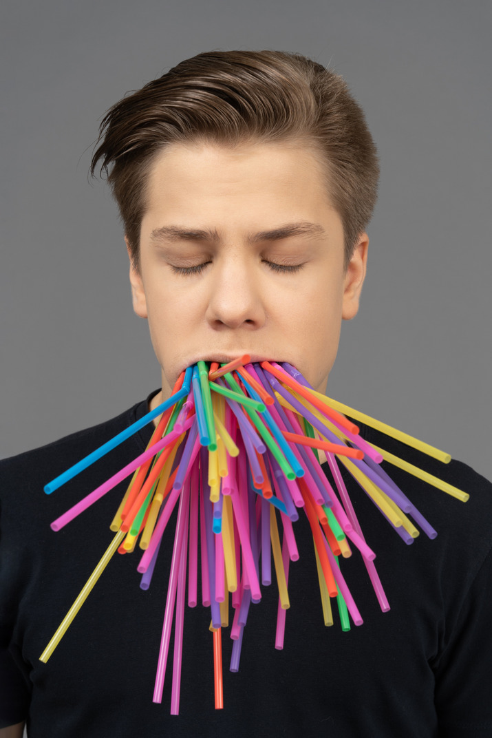 Male model with plastic straws in his mouth