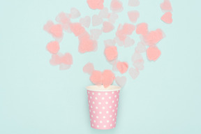 Confetti scattered from polka dot pink paper cup