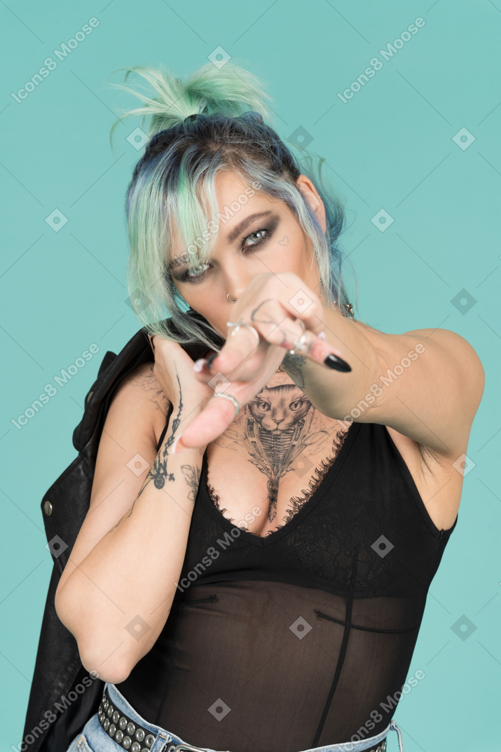 Turquoise haired punk woman pointing to camera with a finger