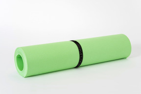 Green yoga mat on a white background