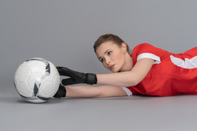 A female goalkeeper catching a ball