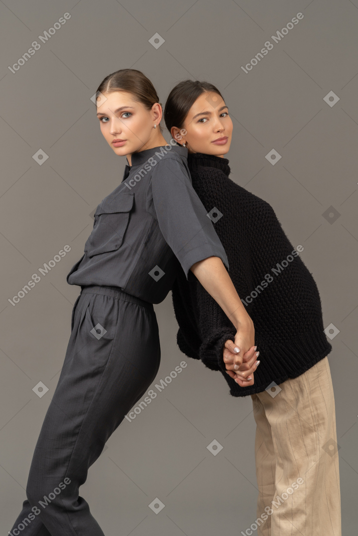 Two women standing back to back