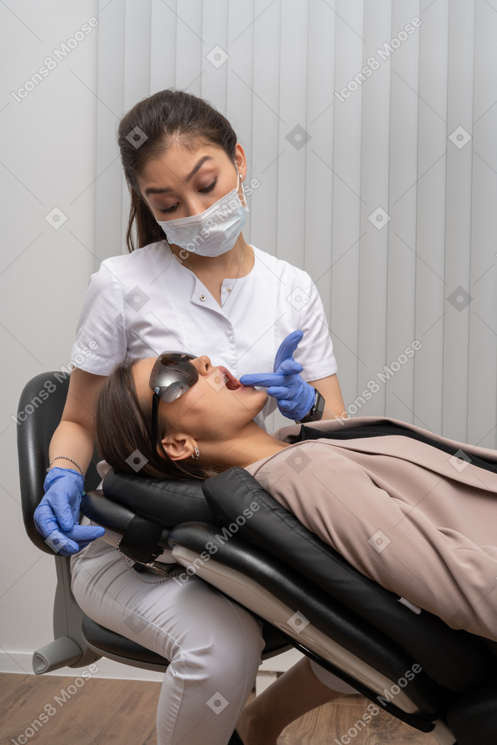 Uma dentista examinando sua paciente