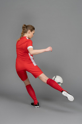 A female football player is about to hit the ball