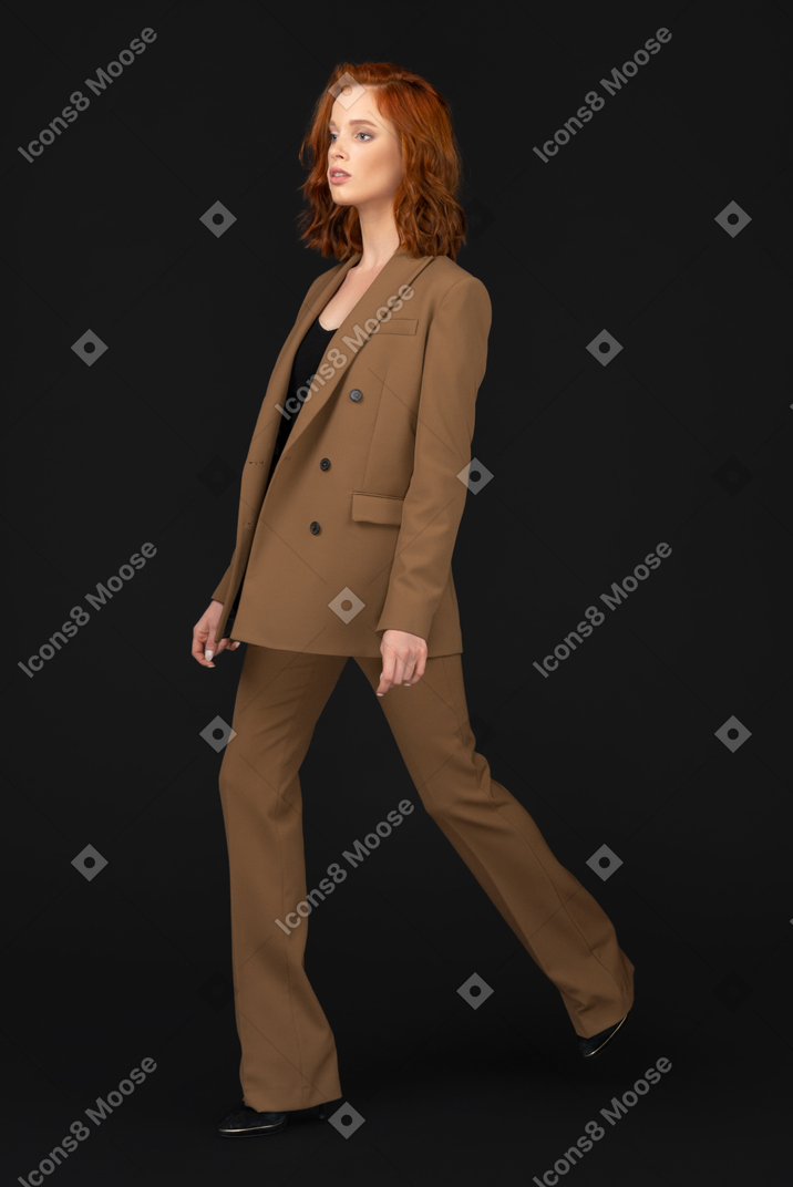 A woman in a brown suit is walking