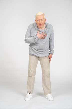 Front view of a man bending with hand on his chest