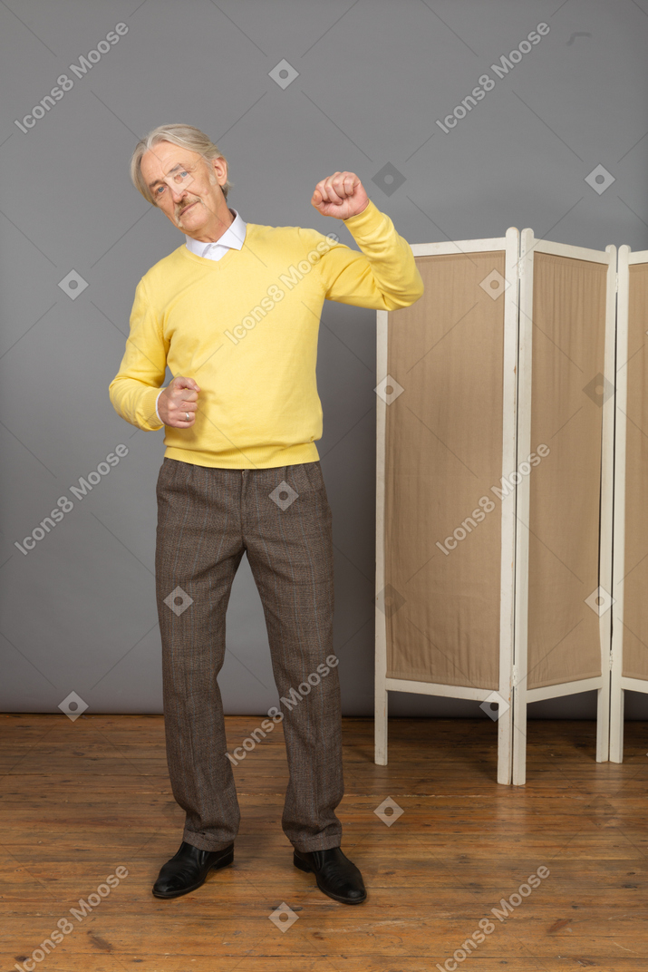 一个老人举起手，握紧拳头的前视图