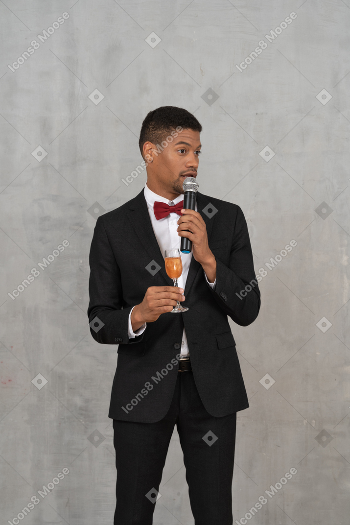 Man holding a glass and giving a speech