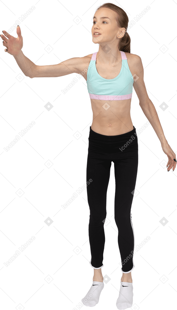 Vista frontal de una jovencita en ropa deportiva levantando la mano mientras dice algo