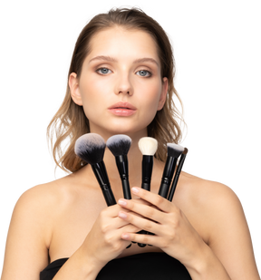 Vue de face d'une jeune femme sensuelle tenant des pinceaux de maquillage