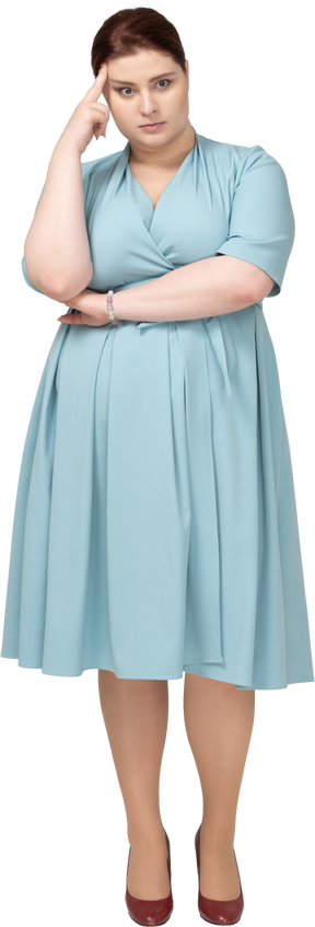 一个穿着蓝色连衣裙思考的女人的前视图