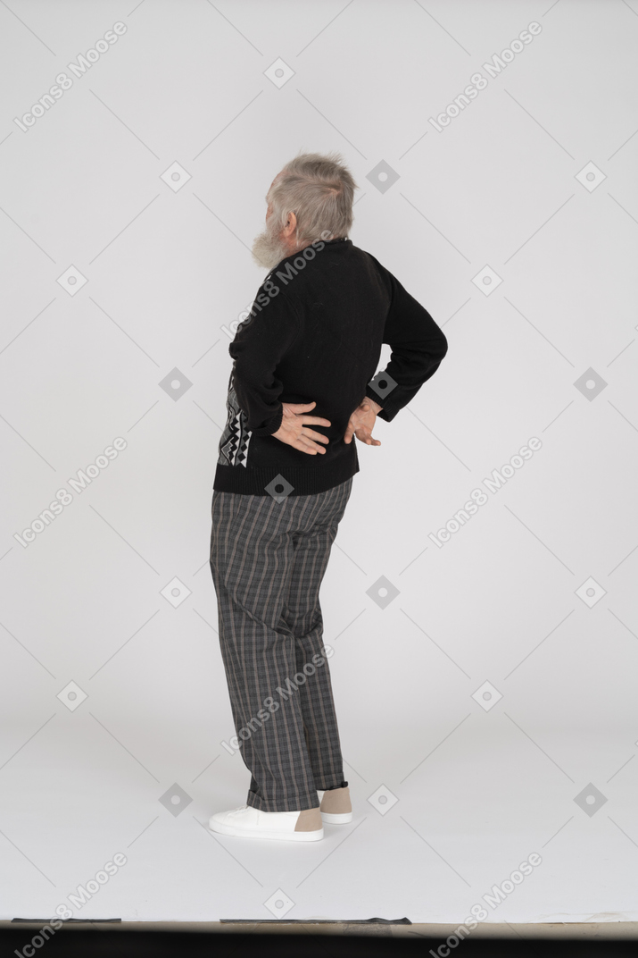 Anciano doblándose hacia atrás y sintiendo dolor en la espalda