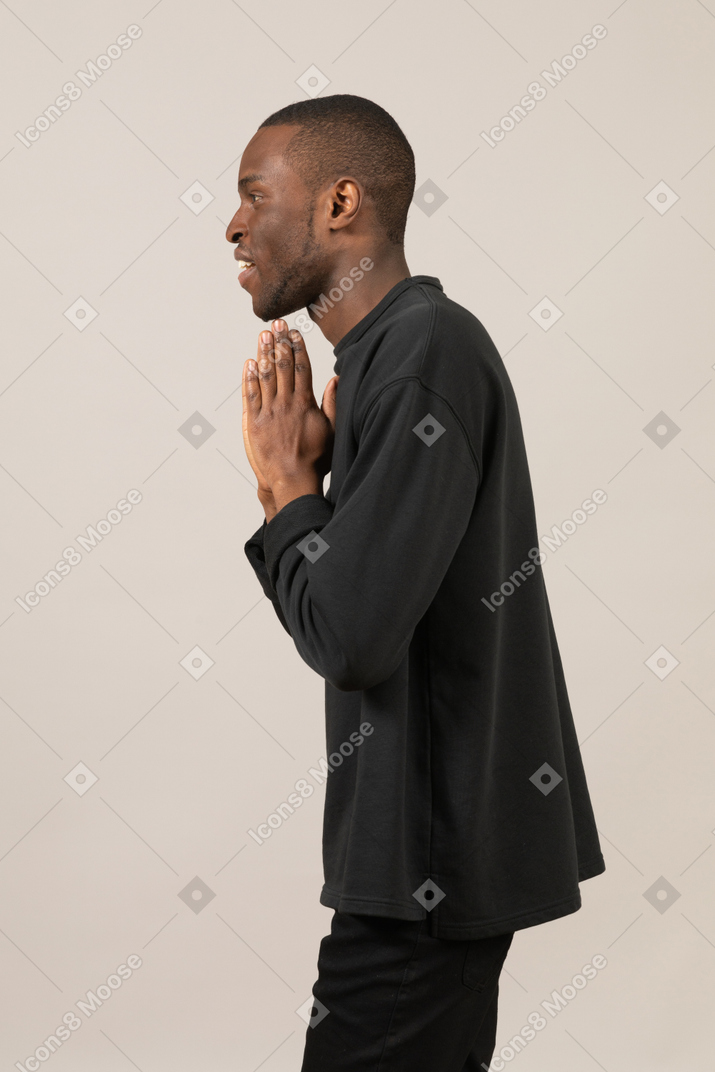 Side view of a man with praying hands