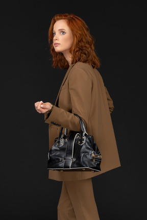 Side view of a young businesswoman with handbag