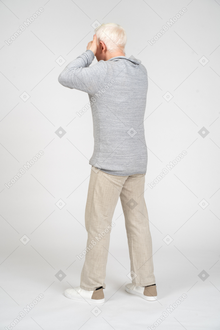 Man walking away and covering his eyes with his hands