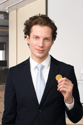 A man in a suit holding a bitcoin