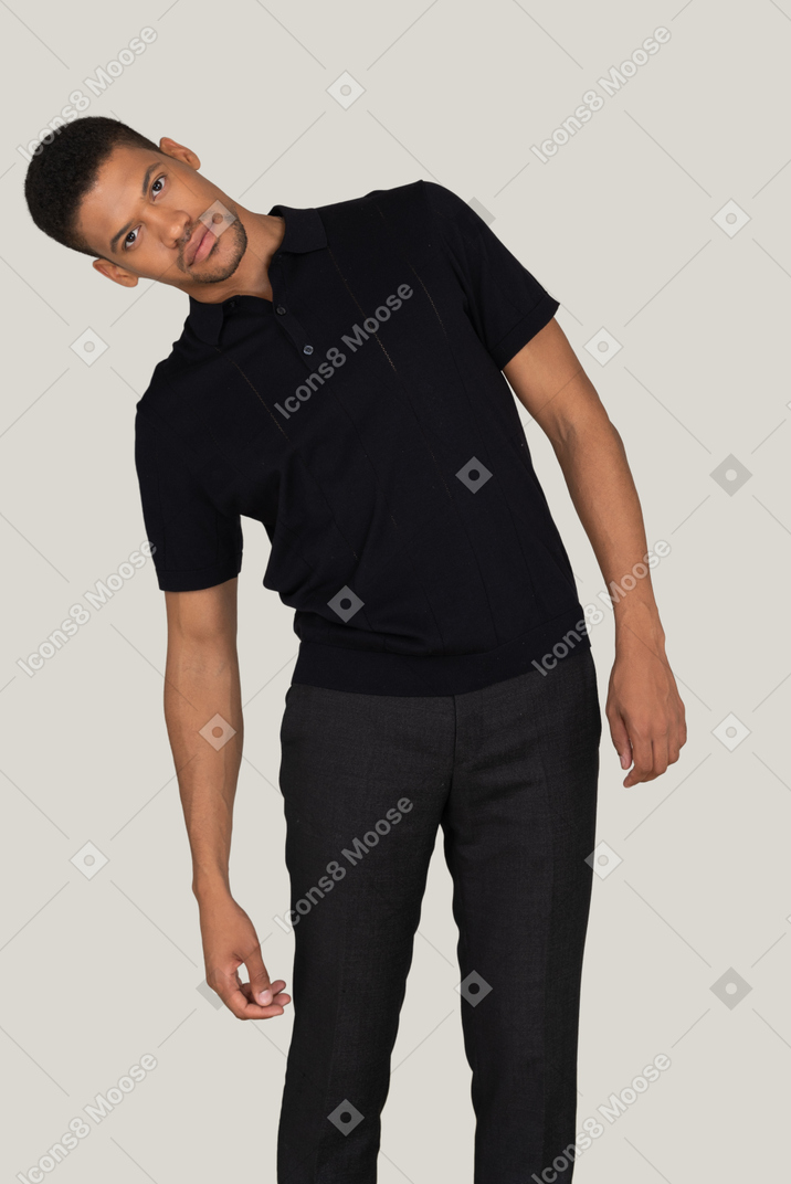 Disturbed young man in black pants and t-shirt looking right into the camera