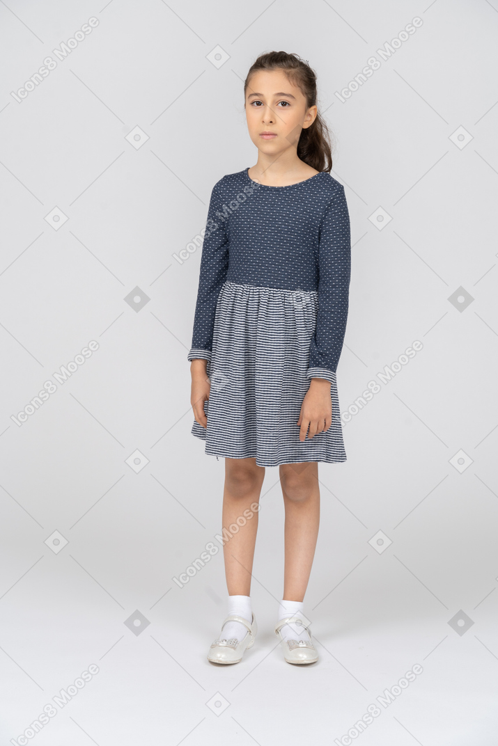Vista frontal de una niña de pie tranquilamente