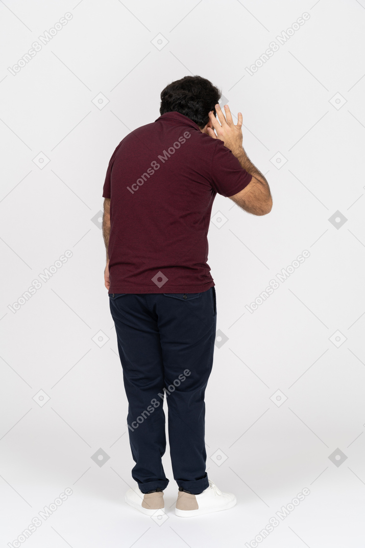 Back view of a man putting hand to ear