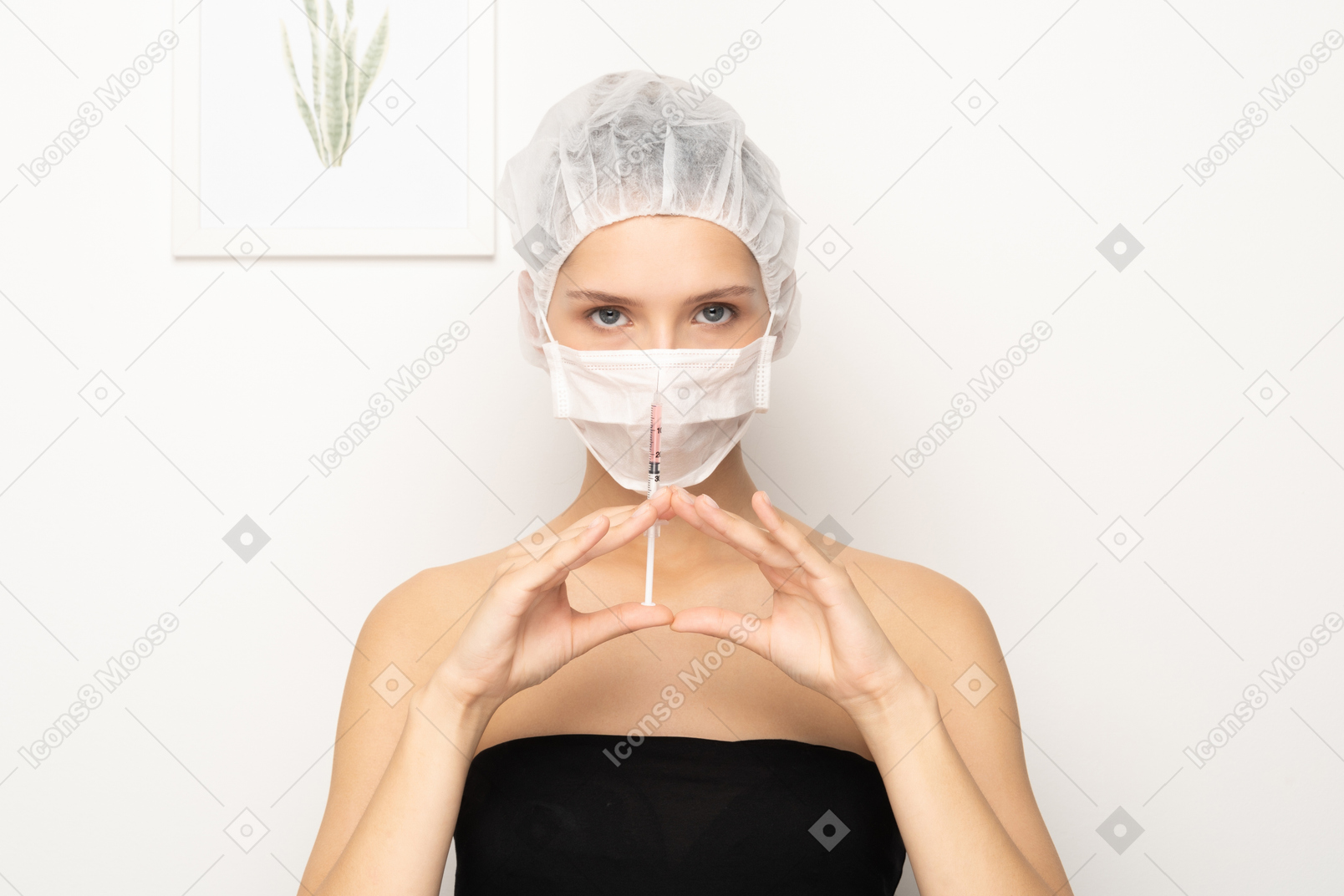 注射器を保持しているマスクの女性