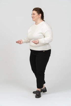 Plump woman in white sweater standing in profile