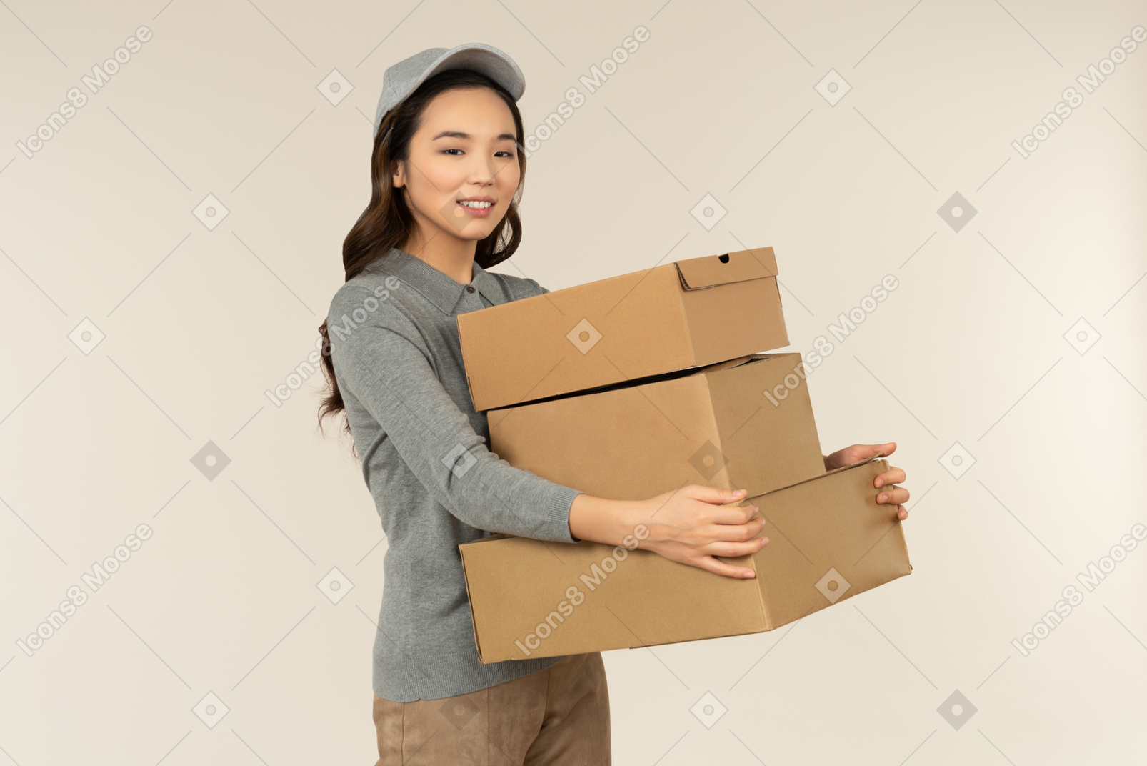 Young asian delivery girl carrying boxes