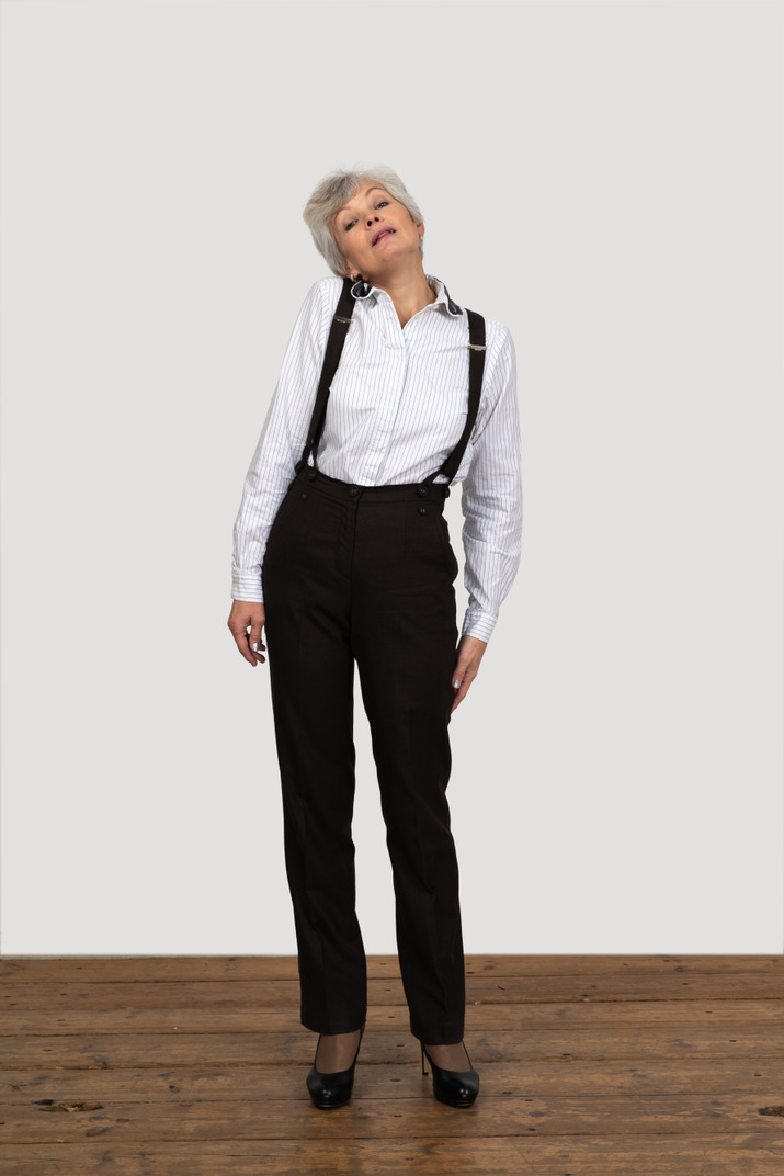 Front view of an old displeased female in office clothes feeling discomfort