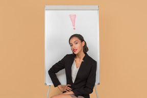 Attractive afro woman sitting by the whiteboard