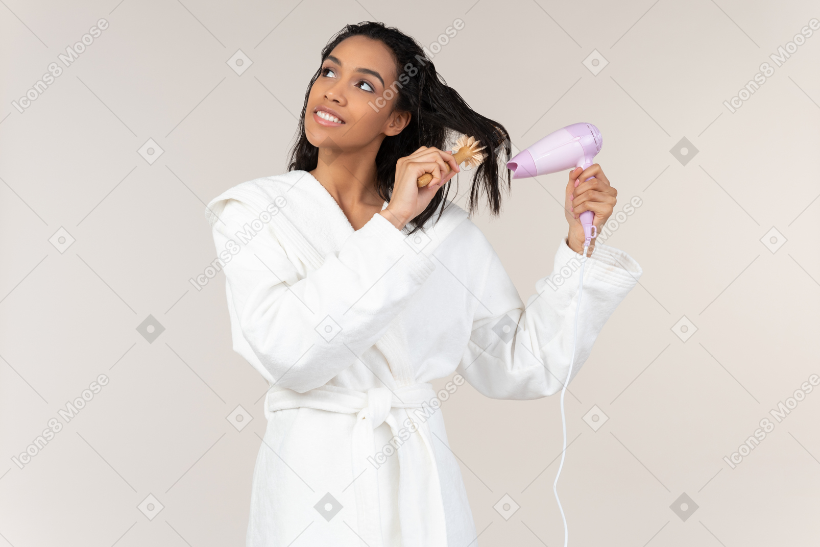 Dreamy young afrowoman drying hair with hair dryer