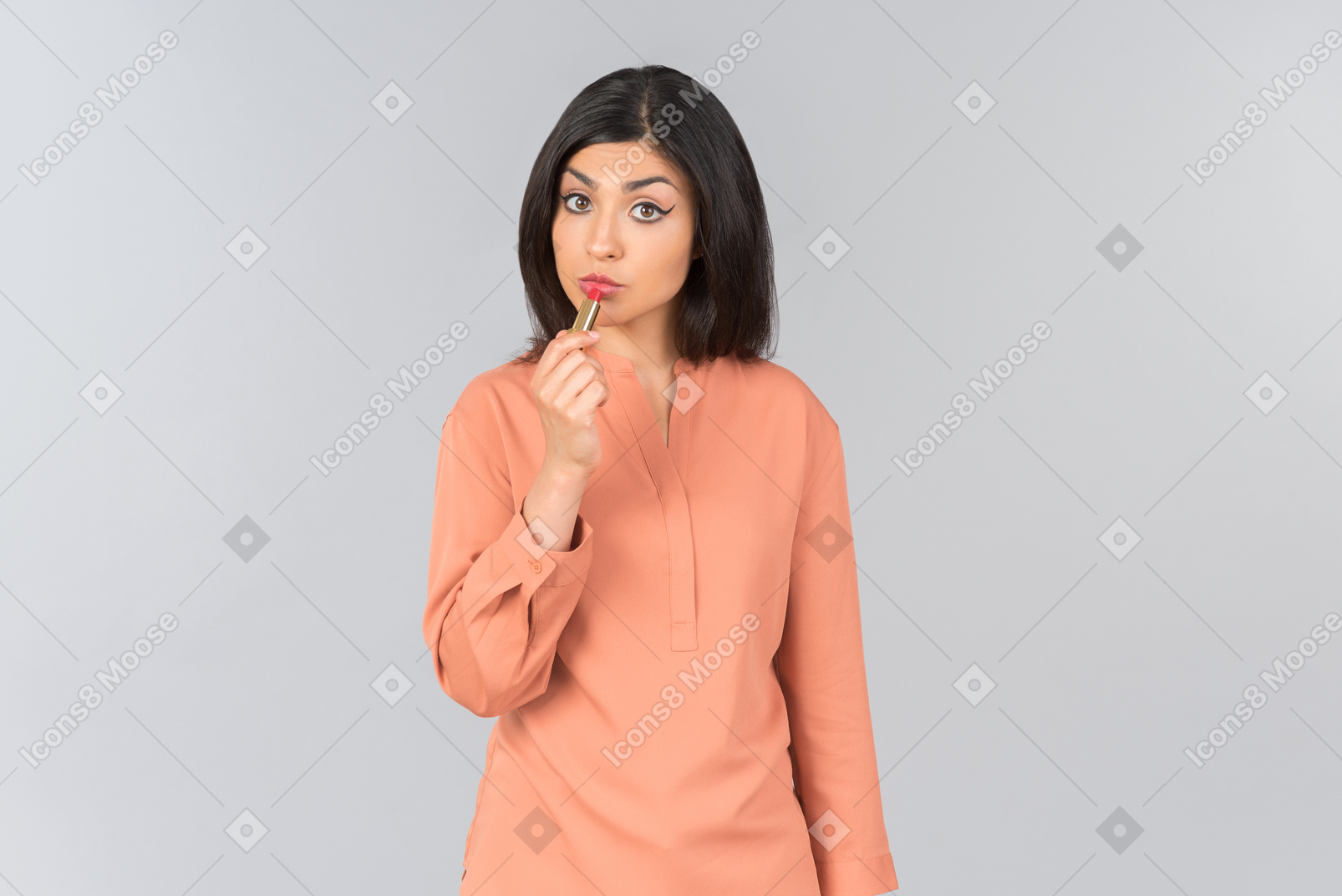 Indian woman applying lipstick