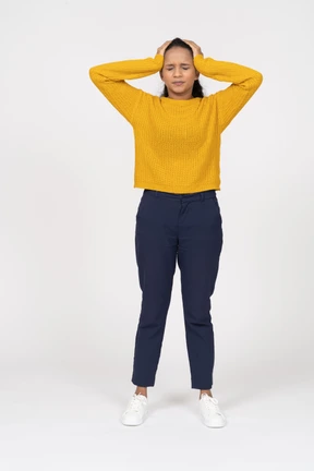 Front view of a girl in casual clothes standing with hands on head