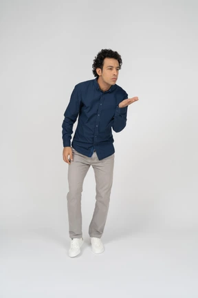 Front view of a man in casual clothes blowing a kiss
