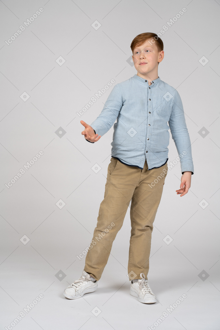 Front view of a cute boy giving a hand for shake