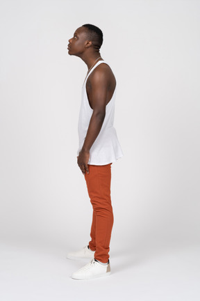Side view of a man in tank top with his neck stretched out