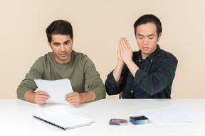 Interracial friends sitting at the table and playing board game