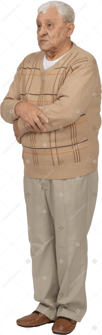 Vorderansicht eines alten mannes in freizeitkleidung, der mit verschränkten armen steht und in die kamera schaut